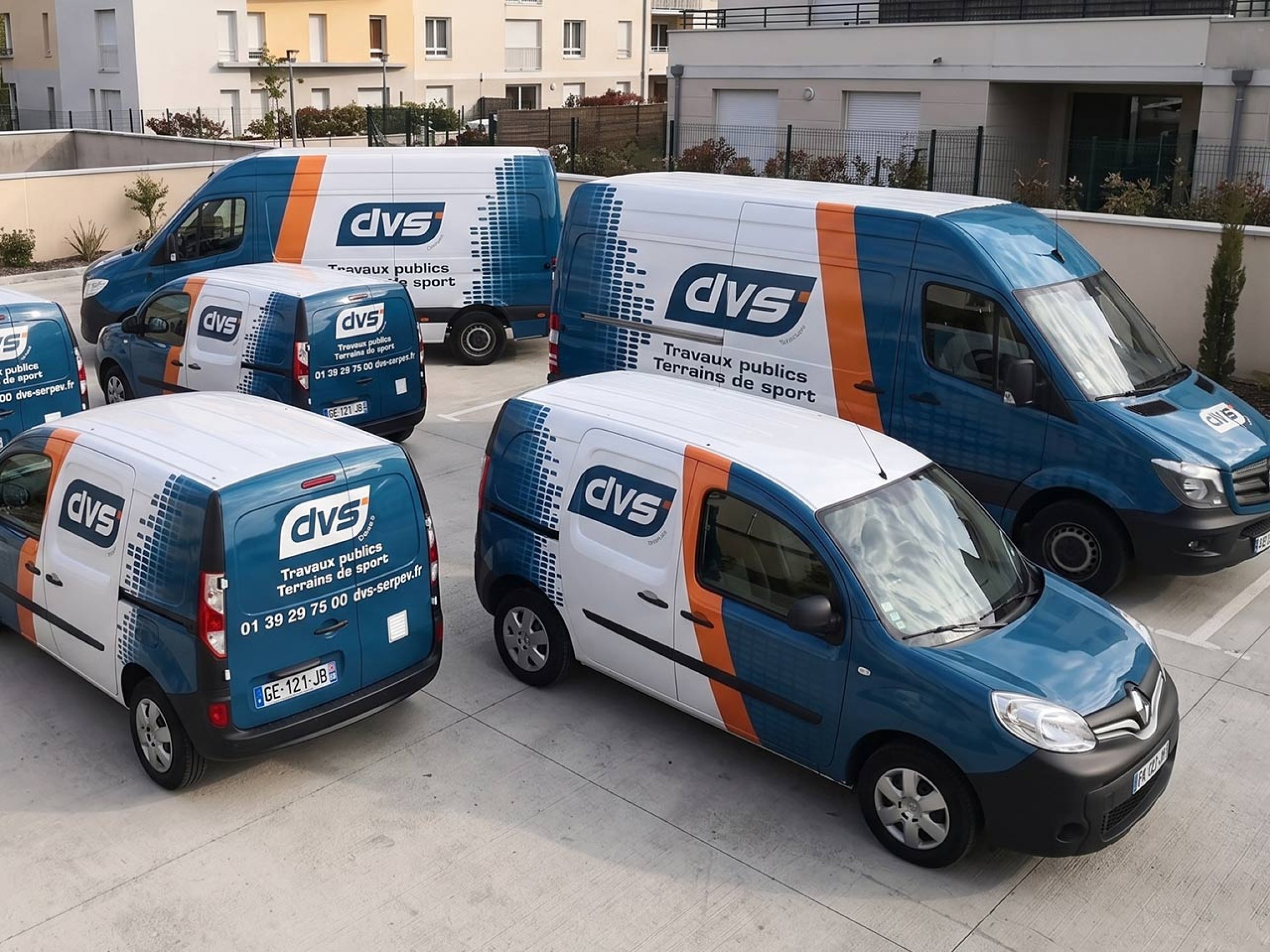 Flotte mixte de véhicules utilitaires et voitures en livrée navy-teal cohérente
